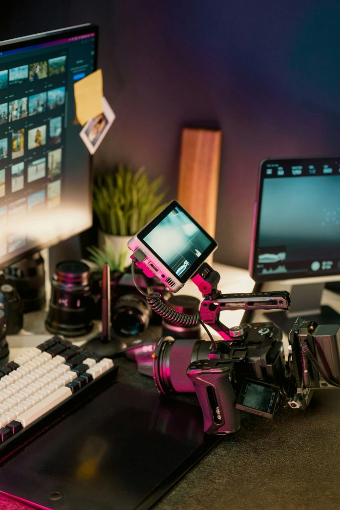filmmakers-desk-with-camera-lenses-and-monitors-xazcgufxee Professional video camera editing setup studio workspace with camera gear, computer screens displaying footage thumbnails, and digital production tools. Perfect environment for content creators and filmmakers